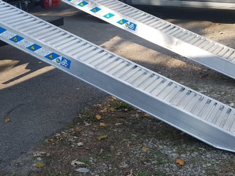 Aluminium ramps extended from the body for loading machinery