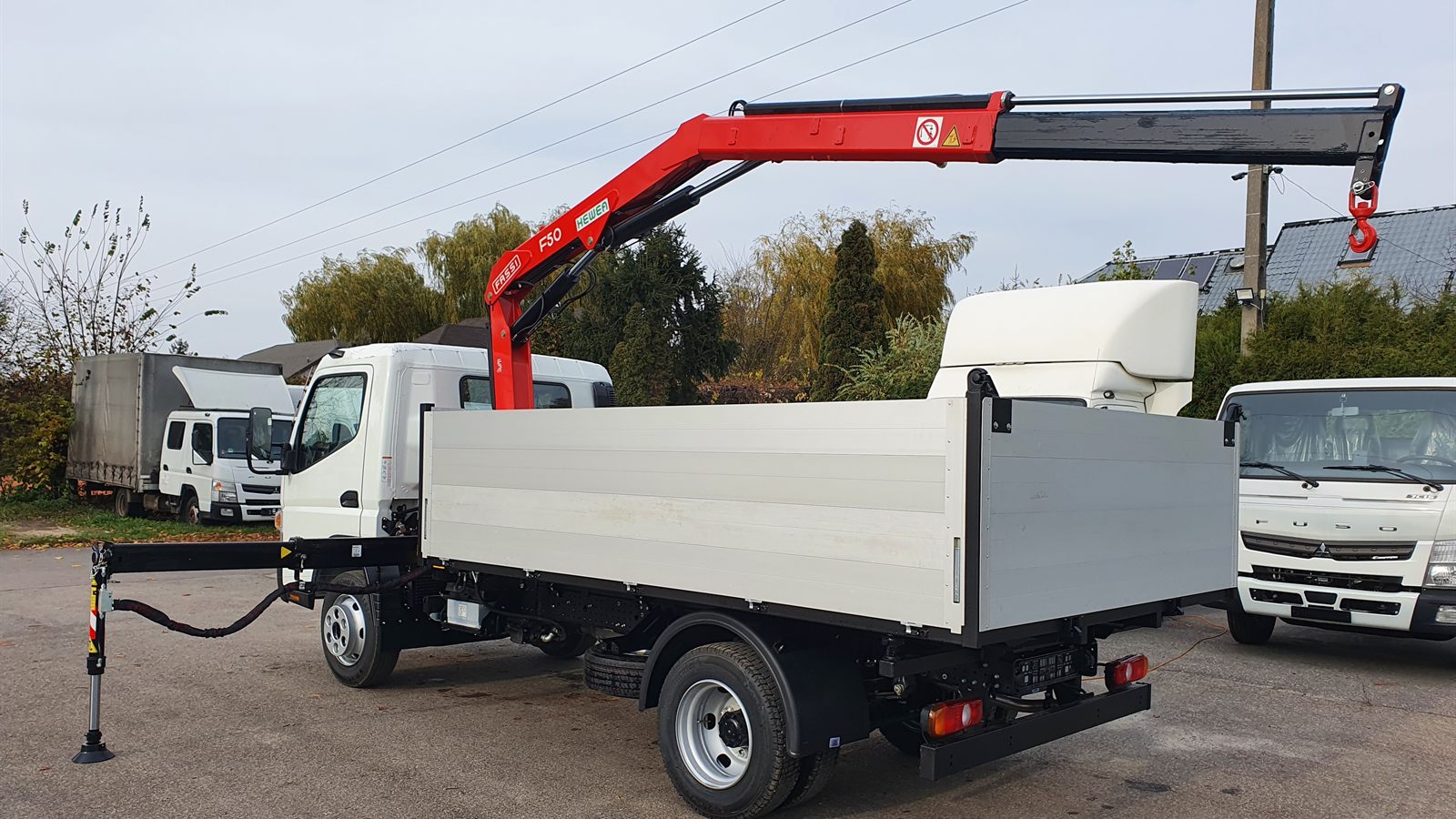 Fassi F50 crane with an outrigger deployed on a flatbed Fuso Canter 9C18